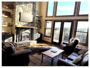a living room with couches and a stone fireplace at Blue Salamander Lodge in Talking Rock +59 photos