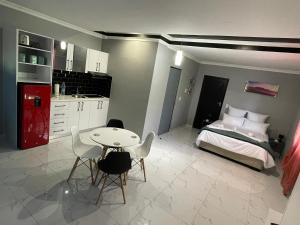 a bedroom with a bed and a table and chairs at Casa de Marcos in Swakopmund