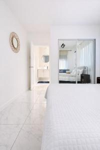 a white bedroom with a bed and a living room at Redhills Escape in Kingston