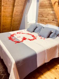 a bed with red flowers on it in a room at Chalè Aurora do vale in Cobras