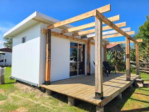 a small white house with a wooden deck at Maridalba 2 in La Coronilla