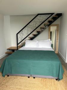 a large bed in a room with a staircase at Cá Por Casa Pico-Faia in Prainha de Baixo