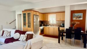 a living room with a white couch and a kitchen at SMART Apartments LOUTRAKI in Loutraki
