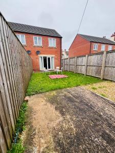 a yard with a fence and a house at Penuel 3-bedroom Retreat with workspace in Central Sutton-in-Ashfield in Sutton in Ashfield