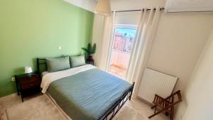 a bedroom with a bed and a window at SMART Apartments LOUTRAKI in Loutraki