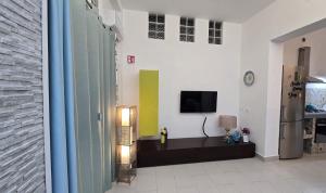 a living room with a tv on a wall at CASA CASCIOTTO in Palermo