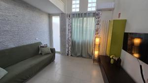 a living room with a couch and a television at CASA CASCIOTTO in Palermo