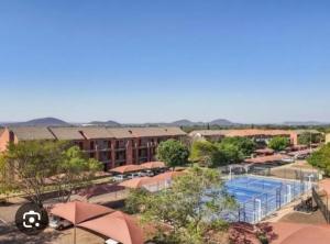 a resort with a swimming pool and a building at Cozy Comfortable Apartment with pool in Pretoria