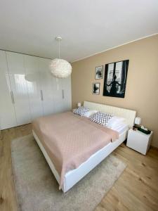 a bedroom with a large bed and a chandelier at Bratislava, LUCAO Family Apartment, Balcony, Free Parking, Aircondition, 8km Old Town in Bratislava