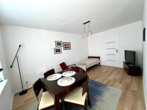 a dining room with a table and chairs and a television at Campus Biebrza - apartamenty biebrzańskie in Osowiec