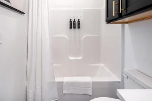 a bathroom with a white shower curtain and a bath tub at Landing Beautiful 2BD in Lees Summit in Lees Summit +64 photos