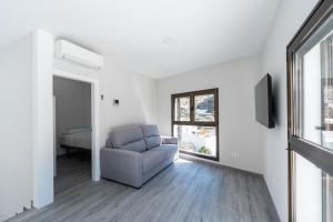 a living room with a chair and a bed at Villa Dasil in San Pedro