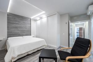 a bedroom with a bed and a chair at Villa Dasil in San Pedro