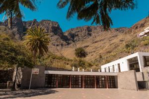 a building with palm trees and mountains in the background at Villa Dasil in San Pedro