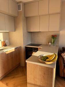 a kitchen with a bowl of bananas and grapes on a counter at BonjourApart in Łódź