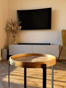 a coffee table in a living room with a tv at BonjourApart in Łódź