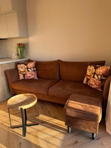 a living room with a brown couch and a table at BonjourApart in Łódź +10 photos