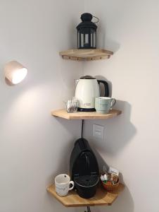 a kitchen with wooden shelves with a toaster and cups at Casa María House in Zubiri
