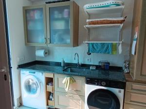 a kitchen with a sink and a washing machine at Casa María House in Zubiri