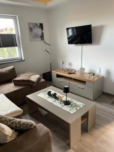 a living room with a coffee table and a flat screen tv at Ferienhaus Usedom in Kamminke