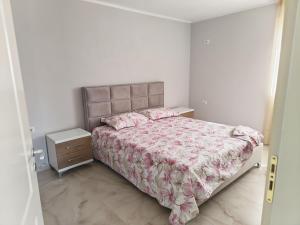 a small bedroom with a bed and a night stand at Ariona apartment in Draç
