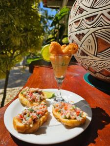 a plate with food and a drink on a table at Hotel Pousada Cachalote in Coruripe