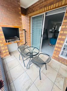a patio with a table and chairs and a television at Brytelight Luxe 1 Bedroom in Rustenburg