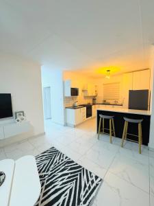 a large white kitchen with a black and white rug at Brytelight Luxe 1 Bedroom in Rustenburg