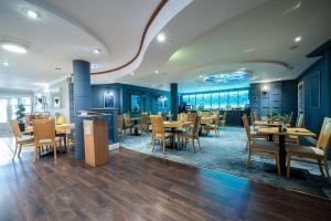 a dining room with wooden tables and chairs at Inn On The Coast in Portrush