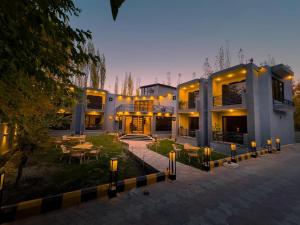 a large building with a courtyard with tables and chairs at The Pioneer Hotel in Skardu