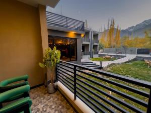 a house with a balcony with green chairs on it at The Pioneer Hotel in Skardu +3 photos