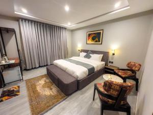 a hotel room with a bed and a table and chairs at The Pioneer Hotel in Skardu