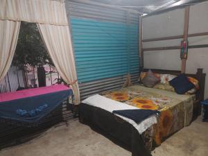 a bedroom with a bed and a window at Casa de playa MC in Quepos