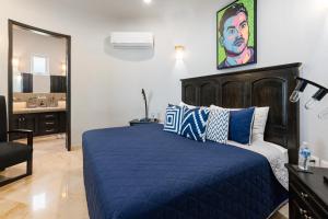 a bedroom with a blue bed and a bathroom at Luxe 3 King BR Villa | Infinity Pool + 220° Views in Puerto Vallarta