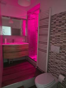 a bathroom with a toilet and a sink and pink lighting at B&B Fede e Natura in Caposele +8 photos