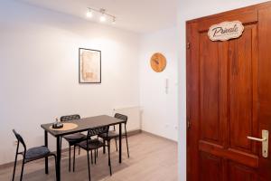a dining room with a table and chairs and a door at Vincellér Apartman in Villány