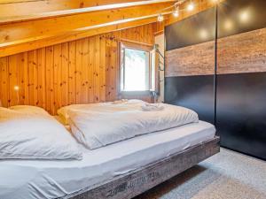 two beds in a room with a wooden wall at Chalet-Apartment mit Balkon & Gratis Parkplatz in Lenk
