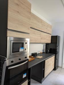a kitchen with a microwave and a black refrigerator at Paddy's Studio in Il-Ħamra
