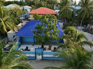 a blue building with a tree in front of it at Ocean Echo Villa in Mathiveri +17 photos