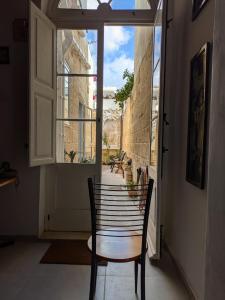 a chair in a room with a window at Paddy's Studio in Il-Ħamra