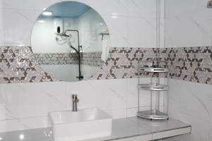 a bathroom with a sink and a mirror at Ocean Echo Villa in Mathiveri