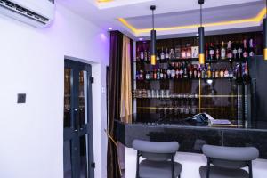 a bar with bar stools and bottles of alcohol at VHS Vinchee Suites II in Lagos