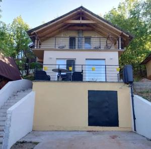 a house with a garage and a fence at Bovan vikendica za izdavanje in Jezero