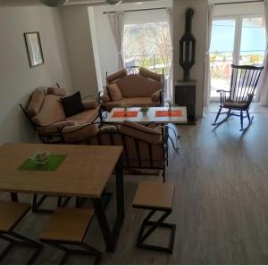 a living room with couches and chairs and a table at Bovan vikendica za izdavanje in Jezero