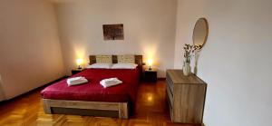 a bedroom with a red bed and a mirror at Casa Leonardo in Tirano