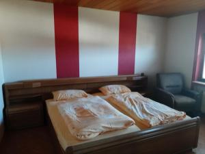 ein Schlafzimmer mit einem Bett und einem Stuhl in der Unterkunft Ferienwohnung Freiling in Wilhelmshütte