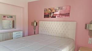 a bedroom with a white bed and a painting on the wall at Villa Maria in Parga