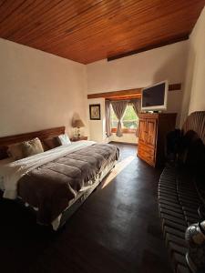 a bedroom with a bed and a flat screen tv at Rustic Escape Between Valle & Avándaro in Valle de Bravo