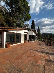 a white building with a patio with potted plants at Rustic Escape Between Valle & Avándaro in Valle de Bravo