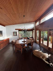 a dining room with a table and a dog laying on the floor at Rustic Escape Between Valle & Avándaro in Valle de Bravo